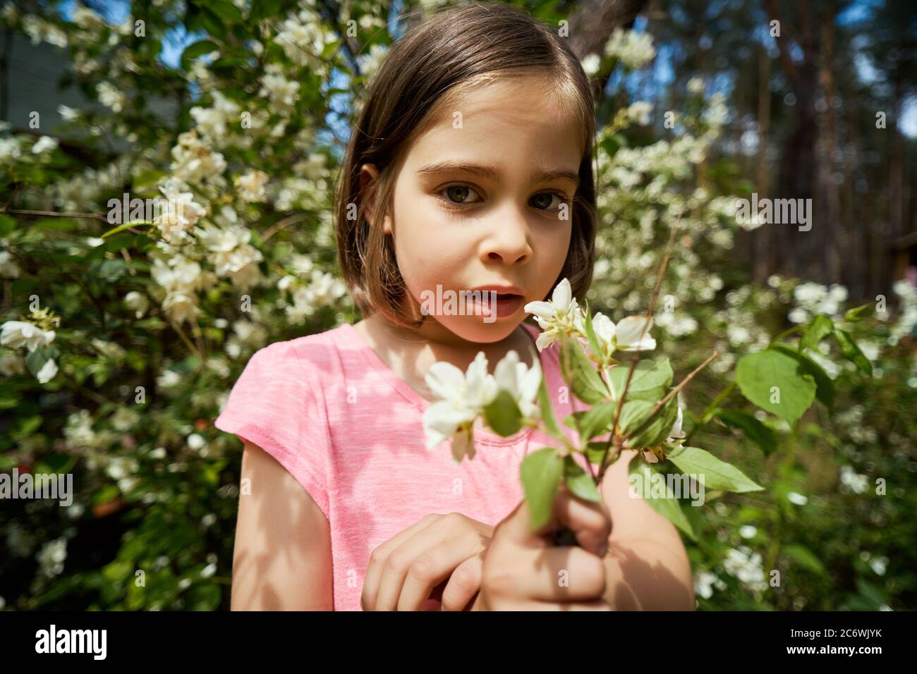 adorable girl making faces with jasmine flower Stock Photo Alamy