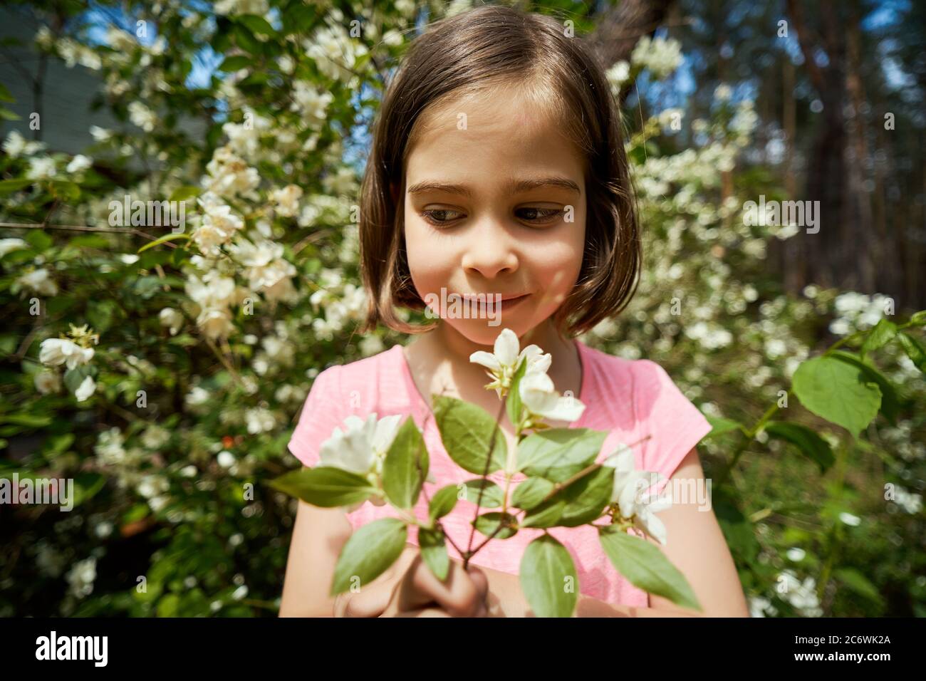 adorable girl making faces with jasmine flower Stock Photo