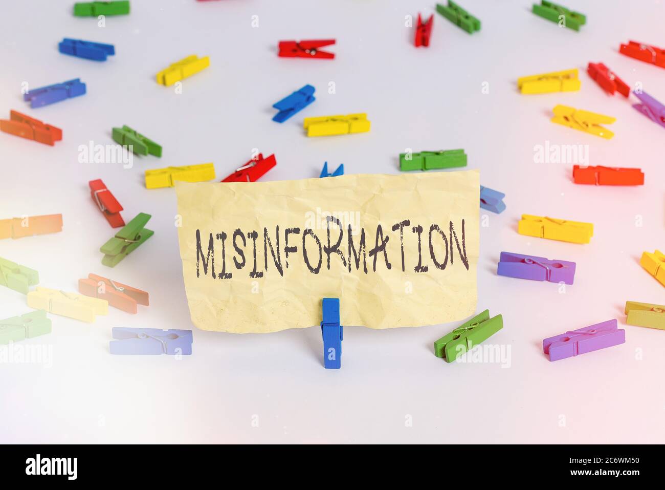 Handwriting text writing Misinformation. Conceptual photo false data, in particular, intended intentionally to deceive Colored clothespin papers empty Stock Photo