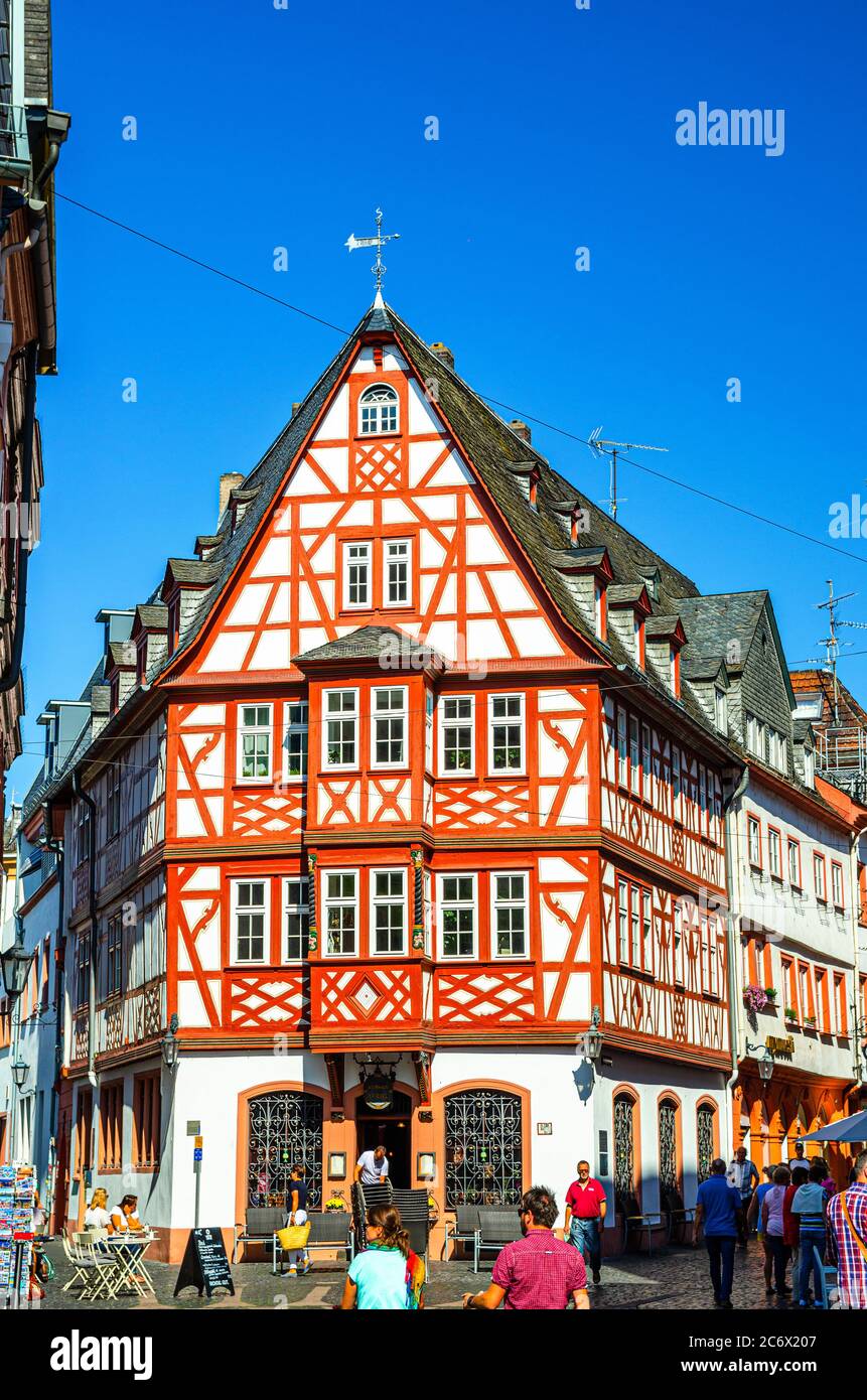 Mainz, Germany, August 24, 2019: Traditional german houses with typical wooden facade fachwerk style and tourists people walking down cobblestone street in historical medieval town centre Stock Photo