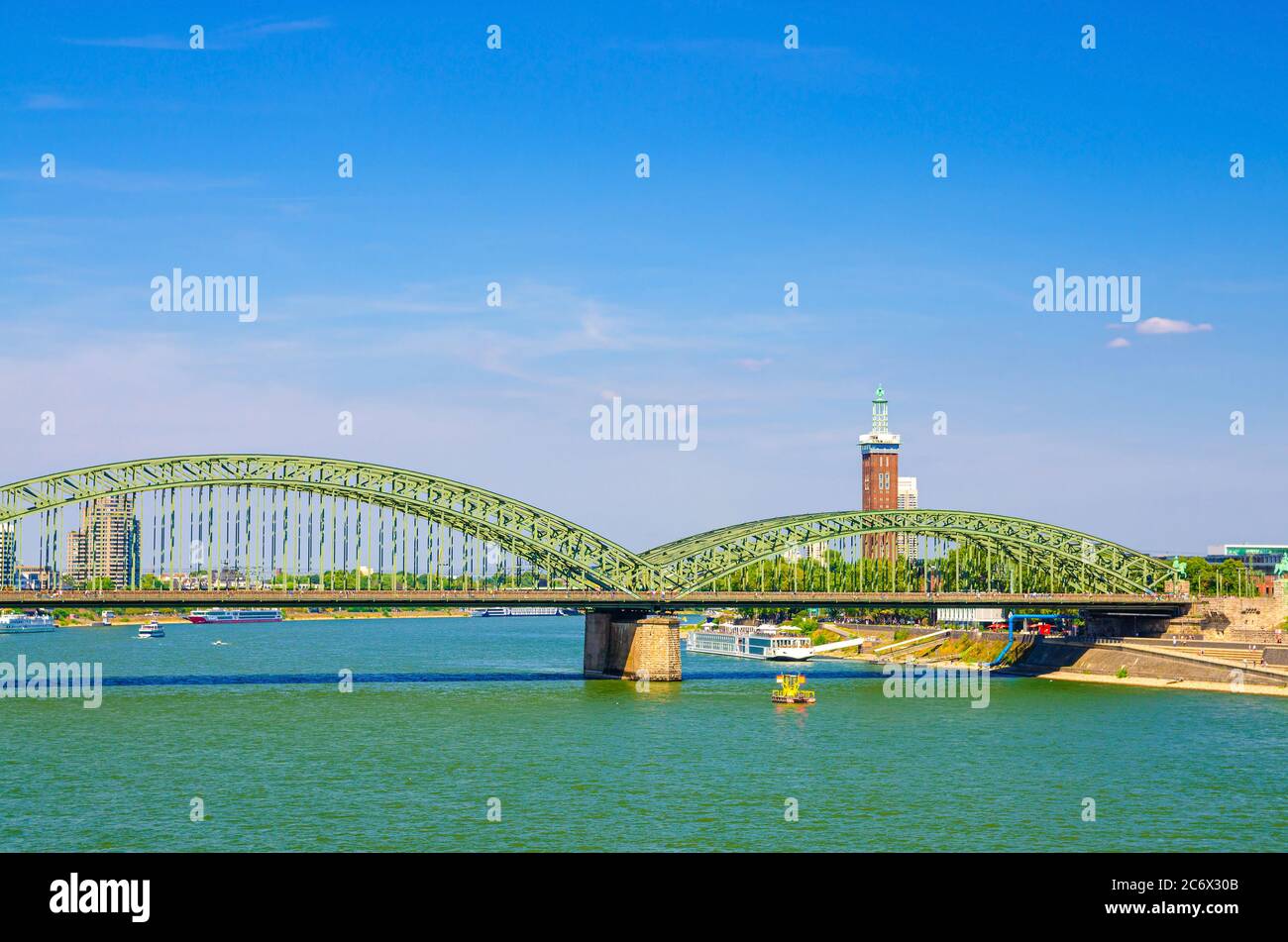 The Hohenzollern Bridge or Hohenzollernbrucke across Rhine river, pedestrian and railway steel bridge in Cologne city centre, blue sky background, North Rhine-Westphalia, Germany Stock Photo