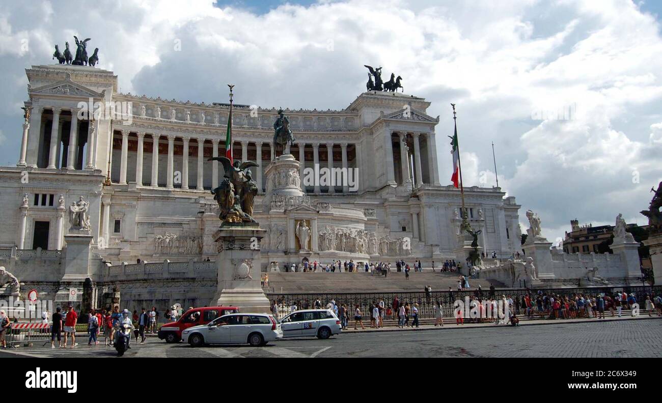 Cars, Motorbikes and visitors pass the Altare della Patria, 'Altar of the Fatherland', National Monument to King Victor Emmanuel II in Rome, Italy. Stock Photo