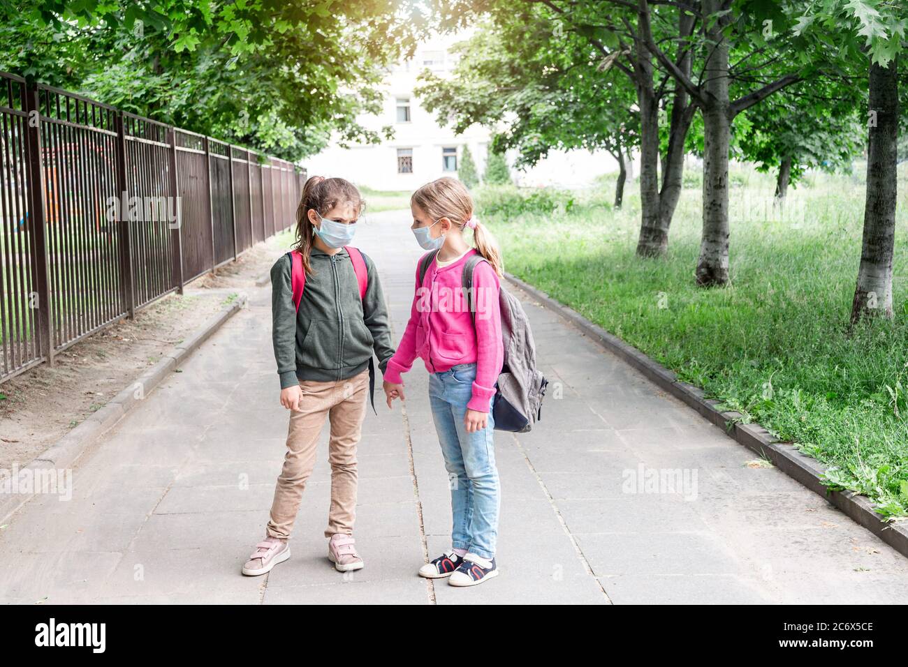 Two girls in protective going back to school during covid-19 pandemic ...