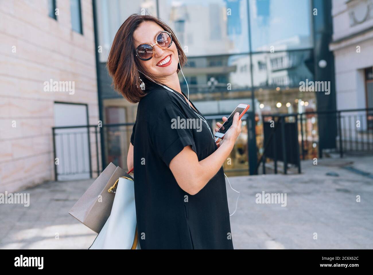 Stylish young woman holding sunglasses hi-res stock photography