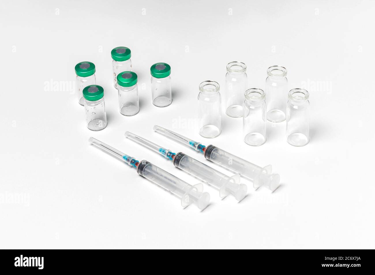 Medical vials with and without caps, hypodermic syringes isolated on white background. Treatment, cure background, top view Stock Photo