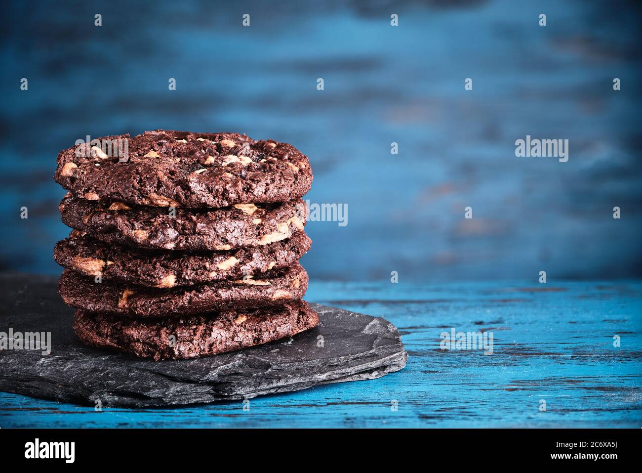 Stack of chokolate cookies on blue wooden background. Stock Photo
