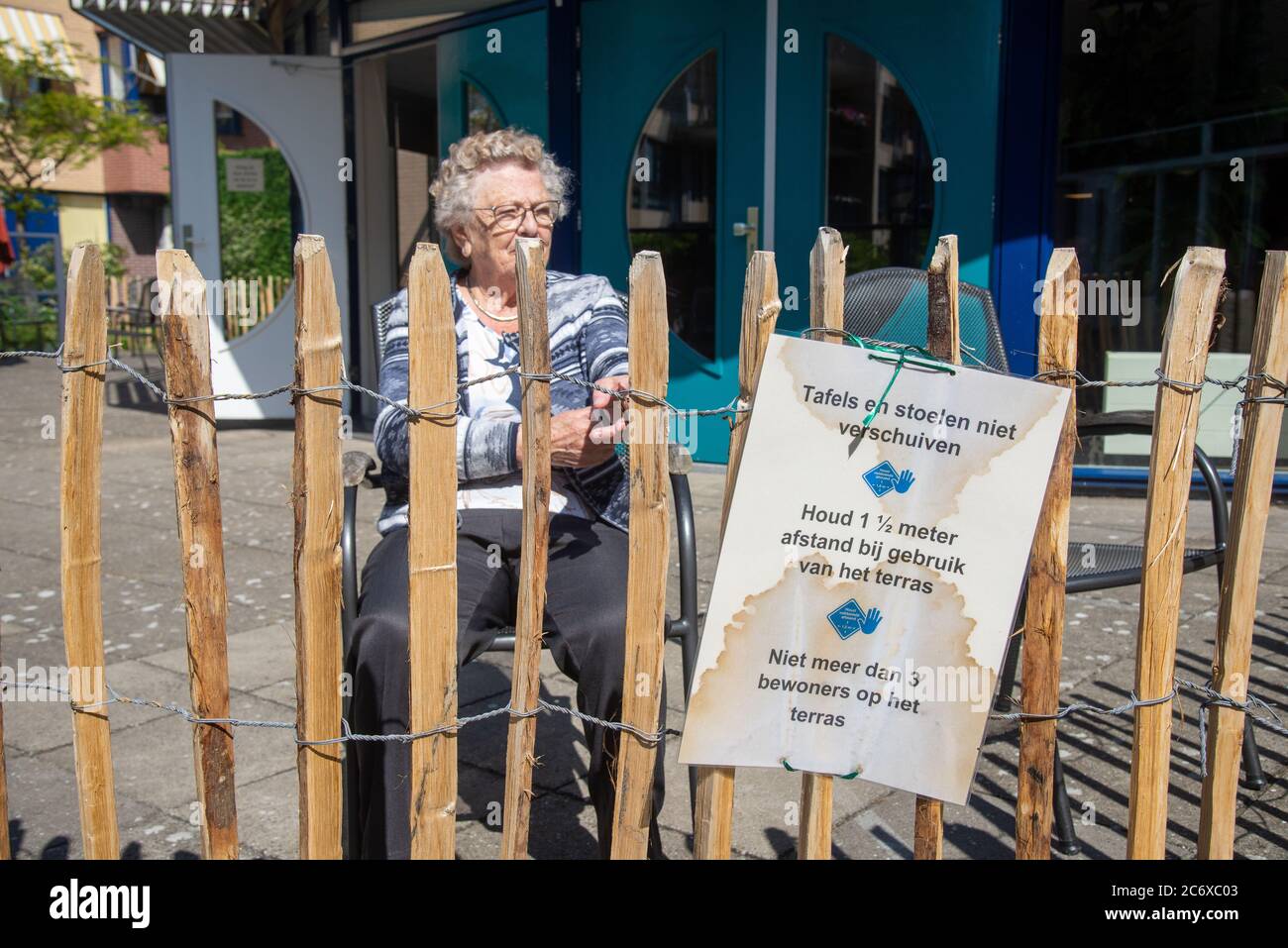 old people behind fence during visit hours in Covid-19 period in house for retired people in Holland Stock Photo