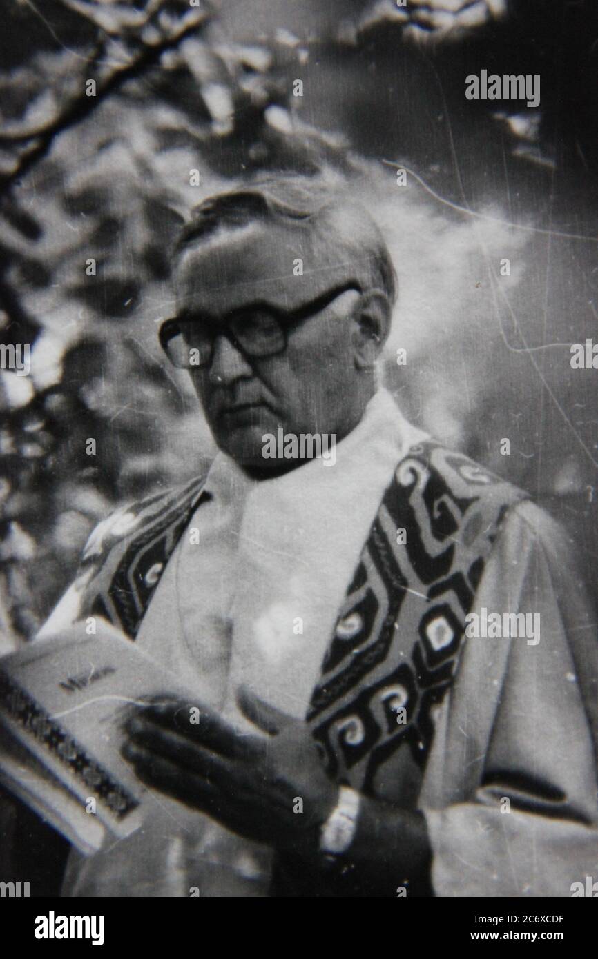 Fine 70s vintage black and white lifestyle photography of priest saying Sunday mass at a summer scout camp. Stock Photo