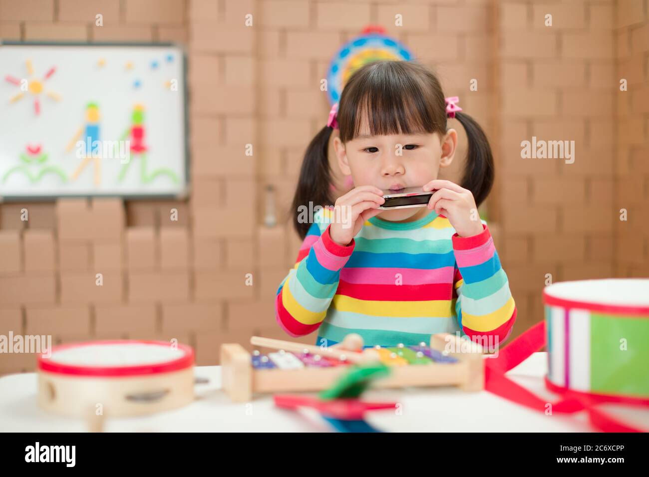 toddler girl play harmonica at home for home schooling Stock Photo Alamy