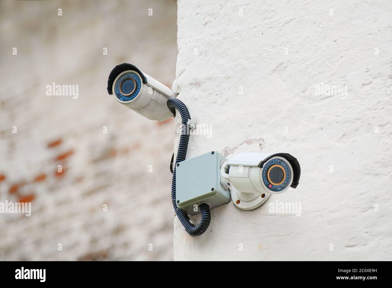CCTV cameras deployed in opposite directions on the wall of a building with  a shallow depth of field Stock Photo - Alamy