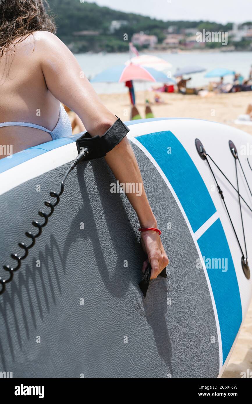 girl carrying a paddle surf board to the sea to practice paddle surf Stock Photo