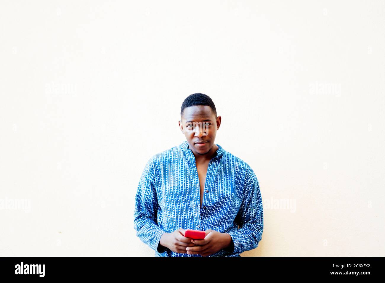 young african man using his red smartphone Stock Photo