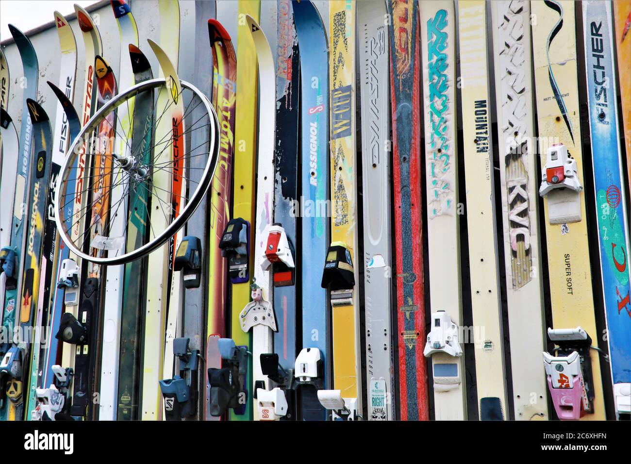 old used snow skis used as decoration and art on a wall near parking