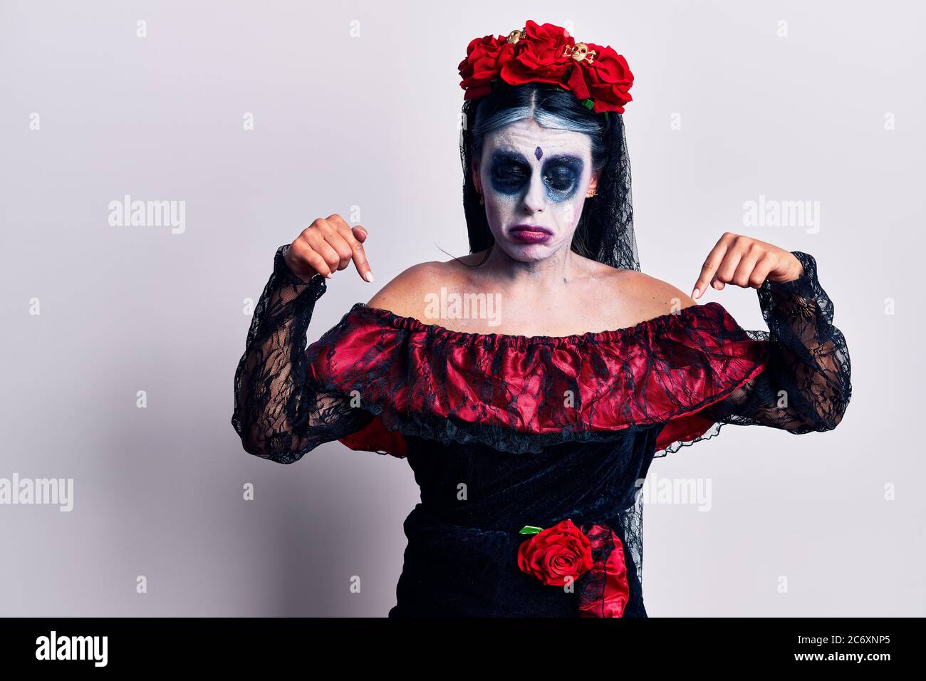 Young woman wearing mexican day of the dead makeup pointing down looking  sad and upset, indicating direction with fingers, unhappy and depressed  Stock Photo - Alamy