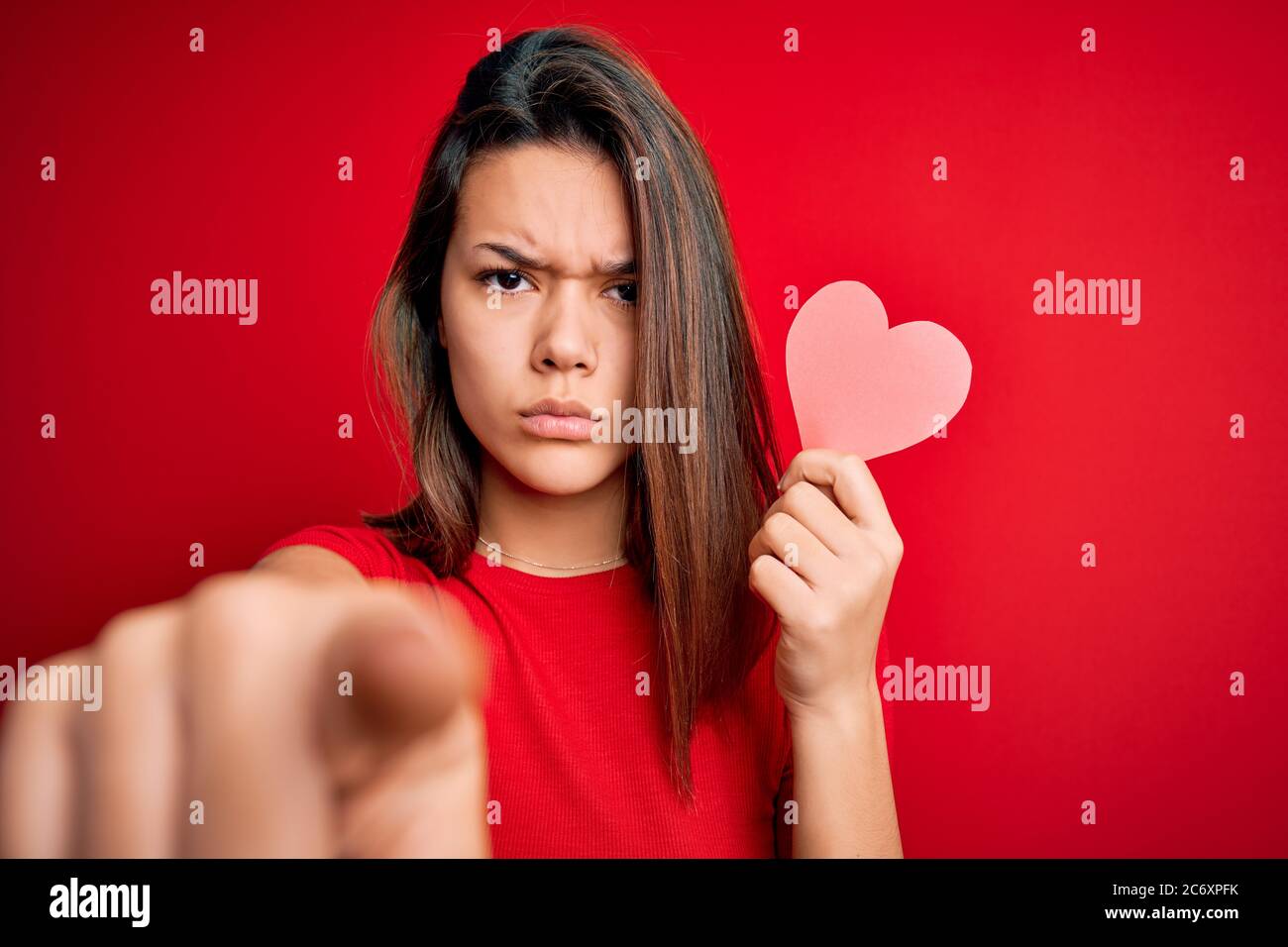 Young beautiful brunette romantic girl holding red paper heart shape ...