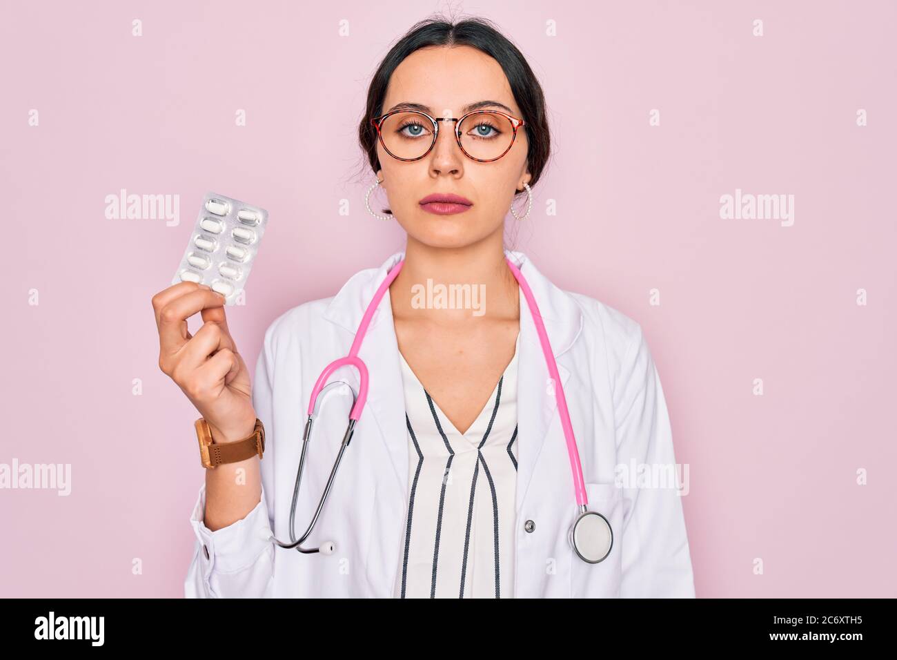 Young beautiful doctor woman with blue eyes wearing stethoscope holding ...