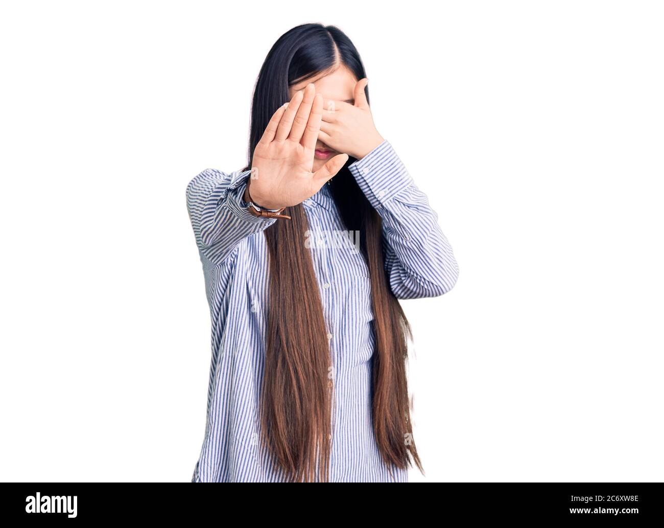 Young beautiful chinese woman wearing casual shirt covering eyes with hands and doing stop gesture with sad and fear expression. embarrassed and negat Stock Photo