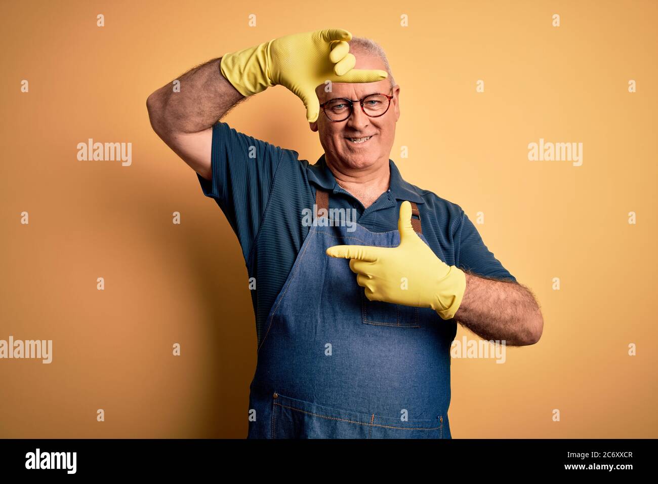 Middle age cleaner man cleaning wearing apron and gloves over isolated ...