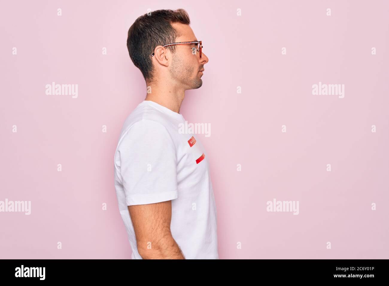 Handsome man with blue eyes wearing sticker with hello my name is ...