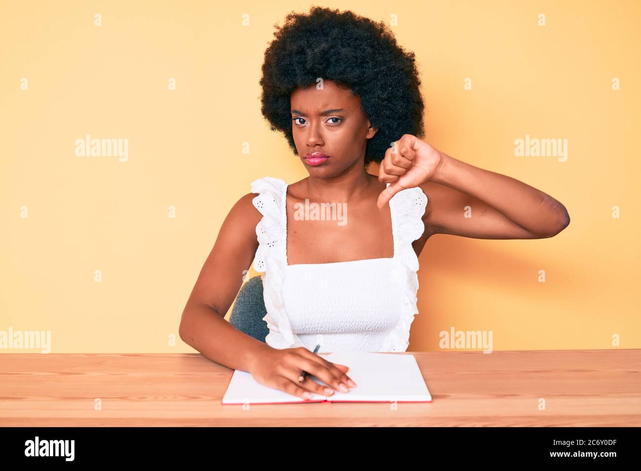 Young african american woman writing book with angry face, negative ...