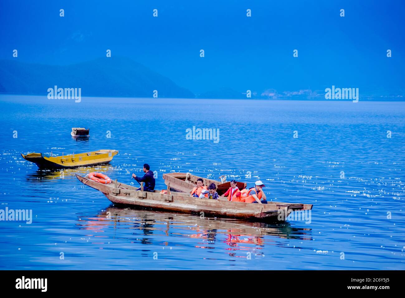 Visitors on a boat enjoy flower blossom of ottelia acuminata, a plant species endemic to Southern China at Lugu Lake in between Ninglang county of Yun Stock Photo