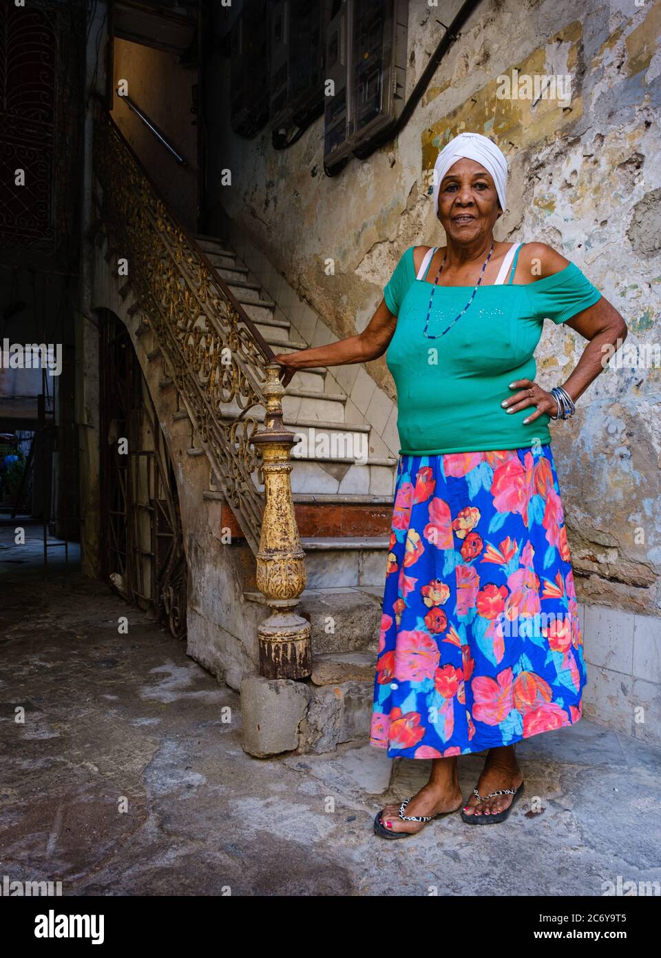 HAVANA, CUBA - CIRCA JANUARY 2020: Portrait of Cuban Woman standing on the entrance of an old building in Havana. Stock Photo