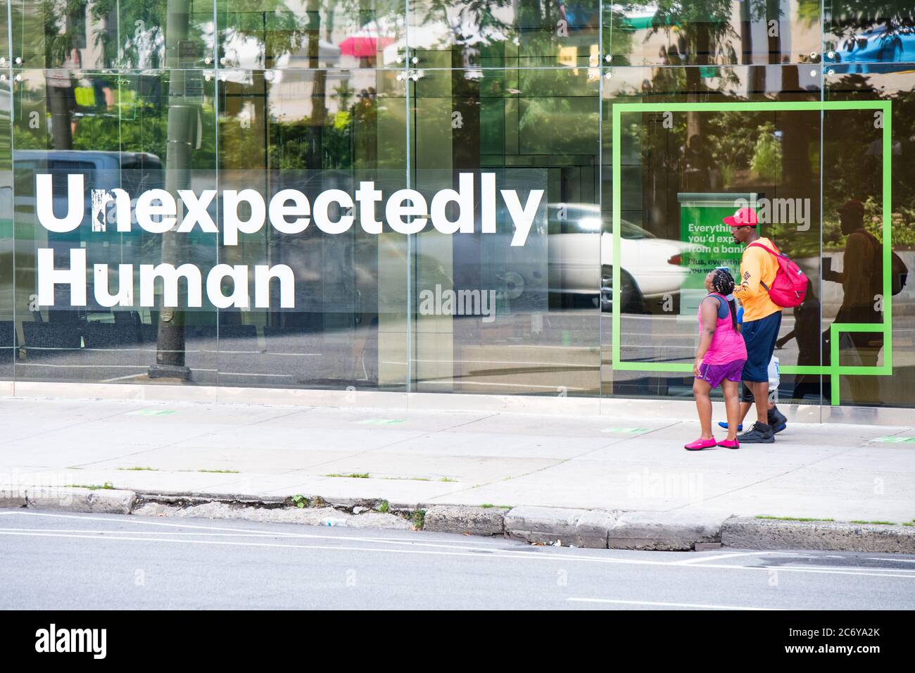Philadelphia / USA. A man and a young girl walk past a sign that says, Unexpectedly Human. July 12, 2020. Credit: Christopher Evens / Alamy Live News Stock Photo