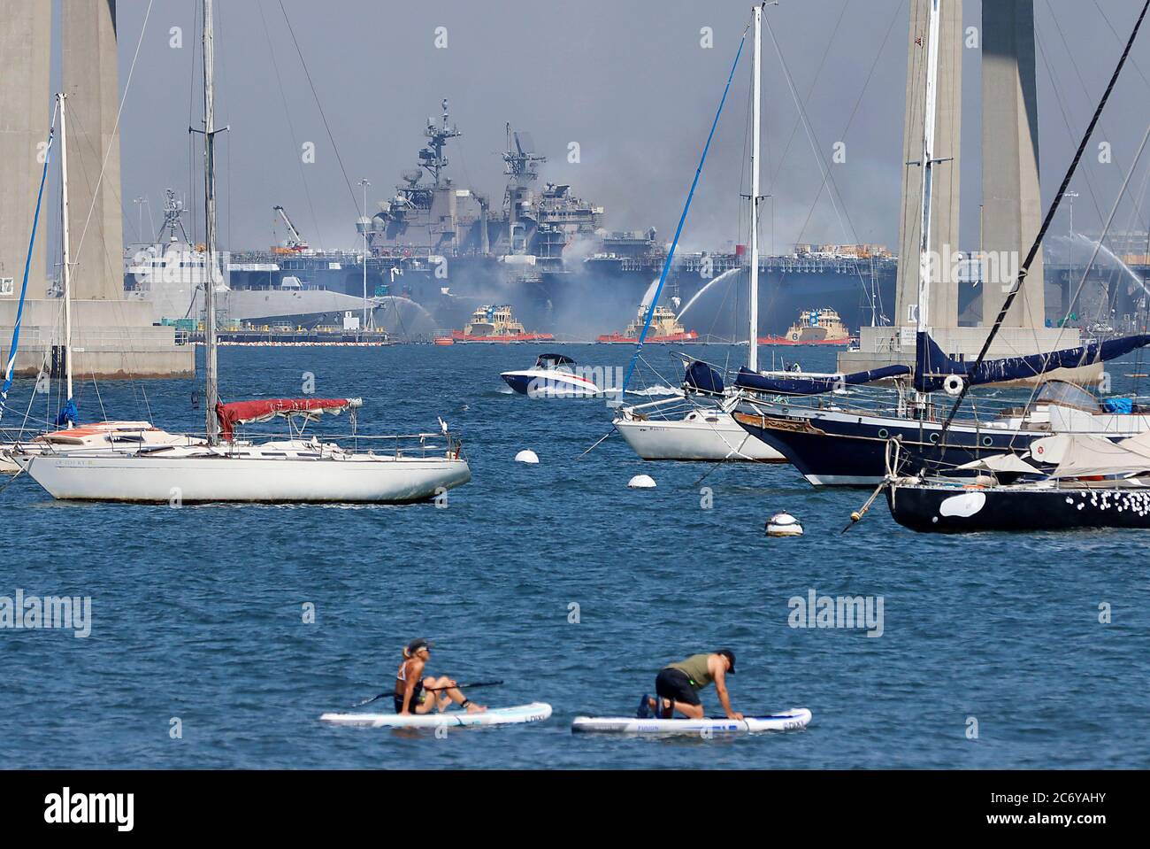 San Diego, CA, USA. 12th July, 2020. In this view from Coronado, CA, the US Navy Ship USS Bonhomme Richard(LHD-6) burns throughout the day after an accident involving a 55-gallon drum used for cleaning tools ignited on the 843-foot amphibious assault ship Sunday morning at San Diego Naval Base. Credit: John Gastaldo/ZUMA Wire/Alamy Live News Stock Photo