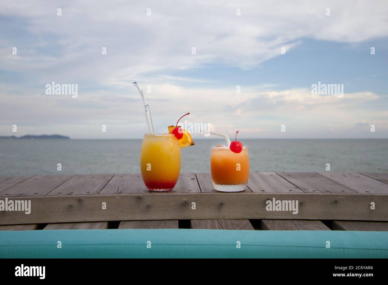 Two glasses of mocktail or fruit punch on wood top with ocean view Stock Photo