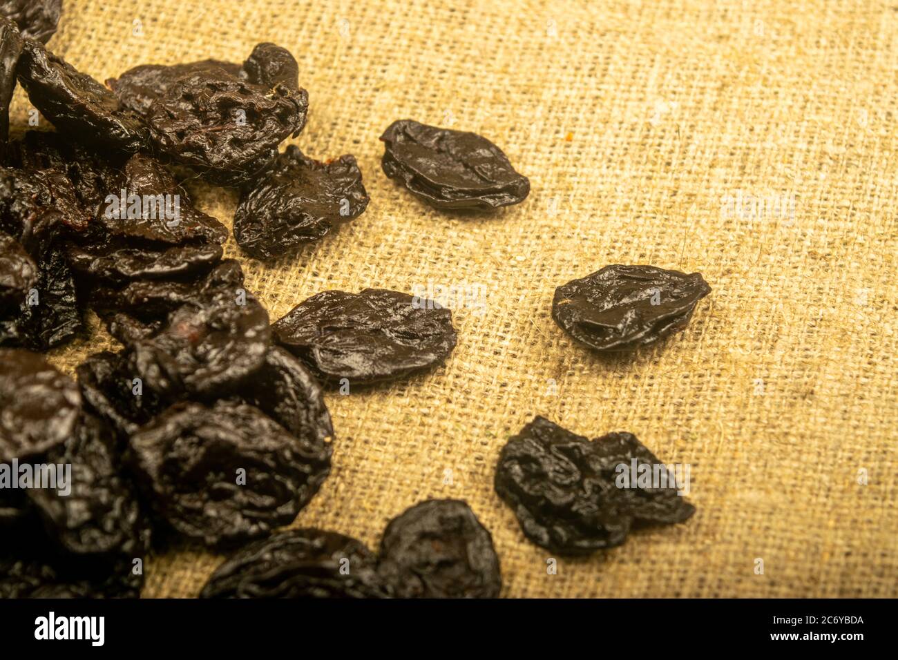 Dried prunes in bulk on burlap with a rough texture. Close up Stock Photo Alamy