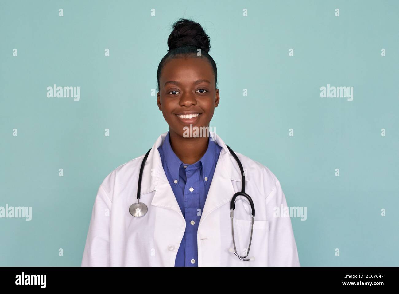 Happy african female doctor looking at camera on mint background, portrait. Stock Photo