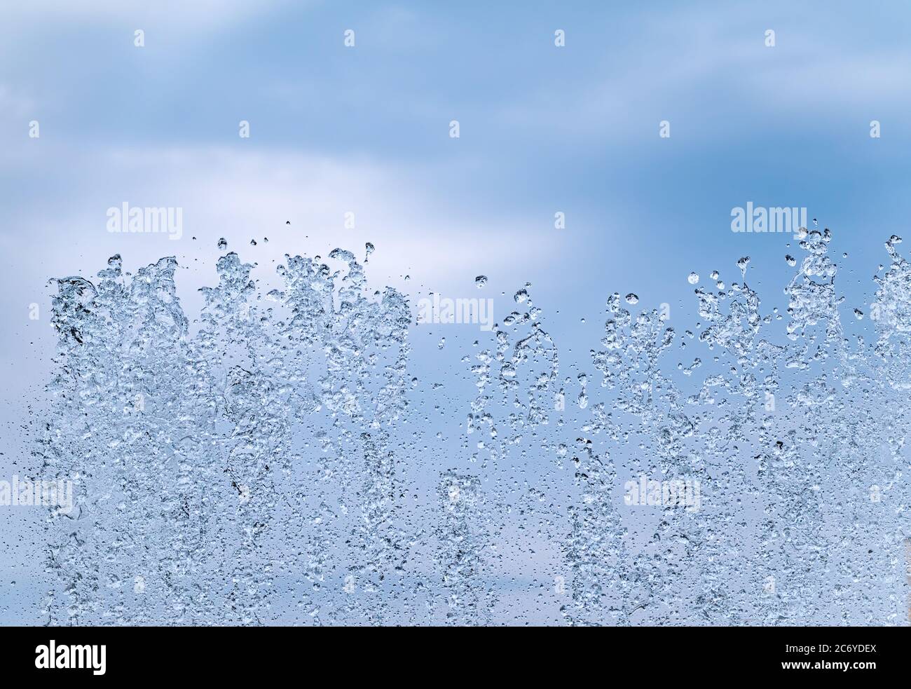 Splashes of water against the blue sky background. Fountain, a jet of ...