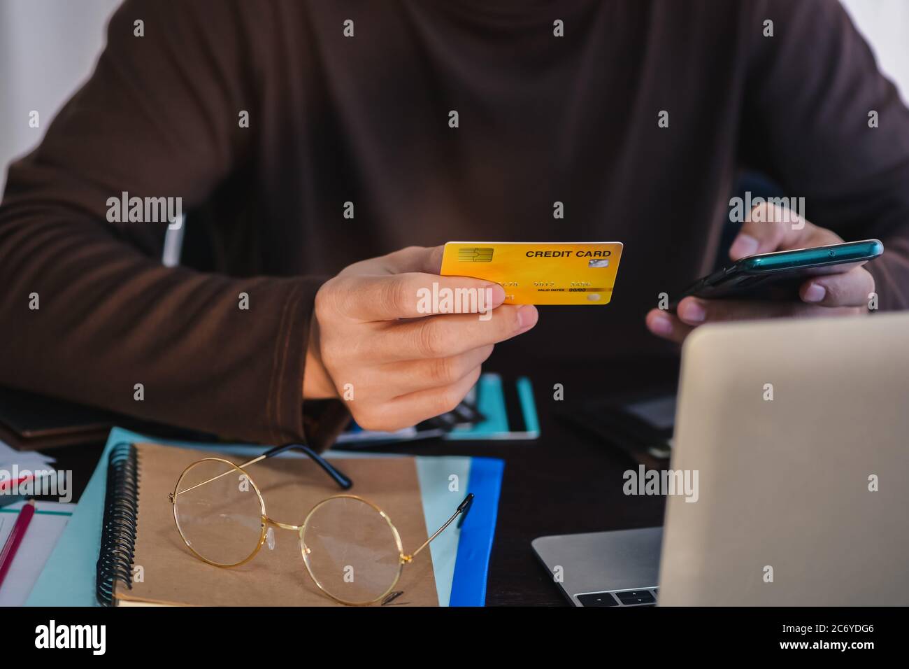 Man paying with credit card on smart phone at home office shopping, banking, home and lifestyle concept Stock Photo