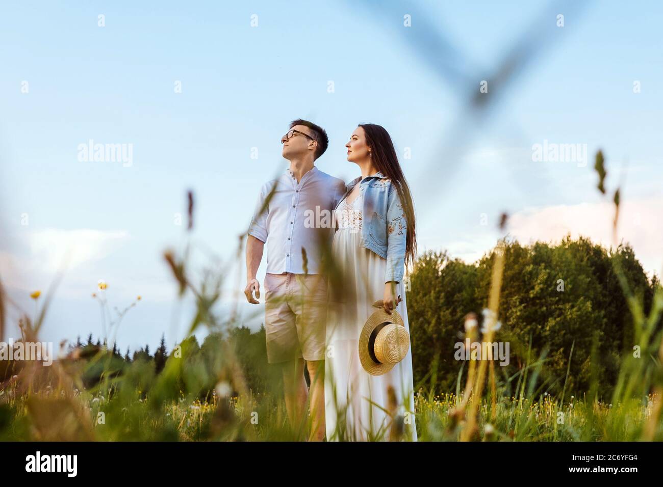A couple in love in the field on beautiful sky background. Profile