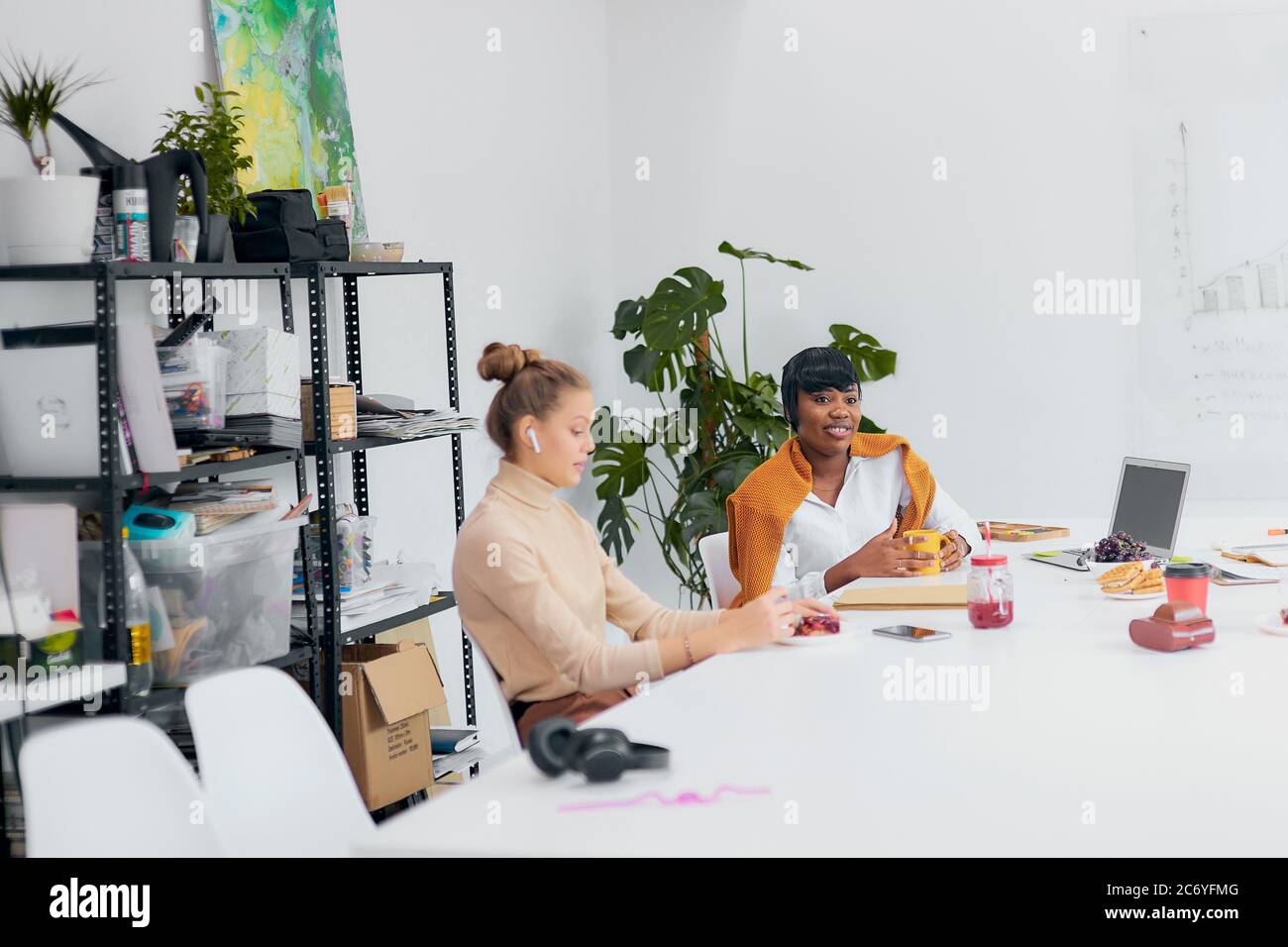 friendly business partners drink tea during free time at workplace ...