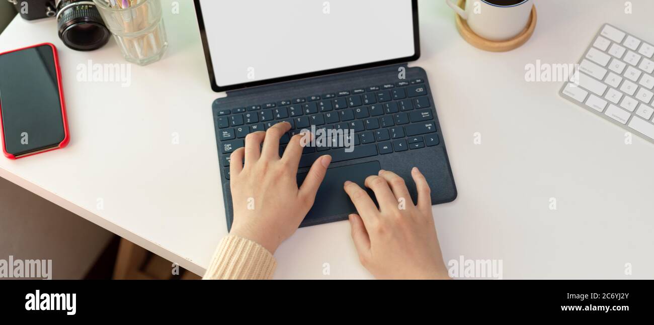 Overhead shot of female typing on mock up tablet with keyboard on white ...