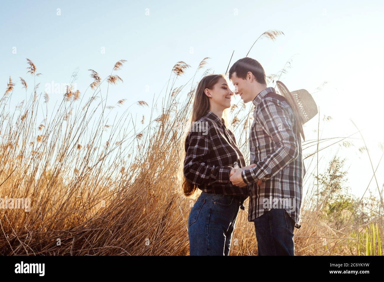 A couple in love in the field on beautiful sky background. Profile