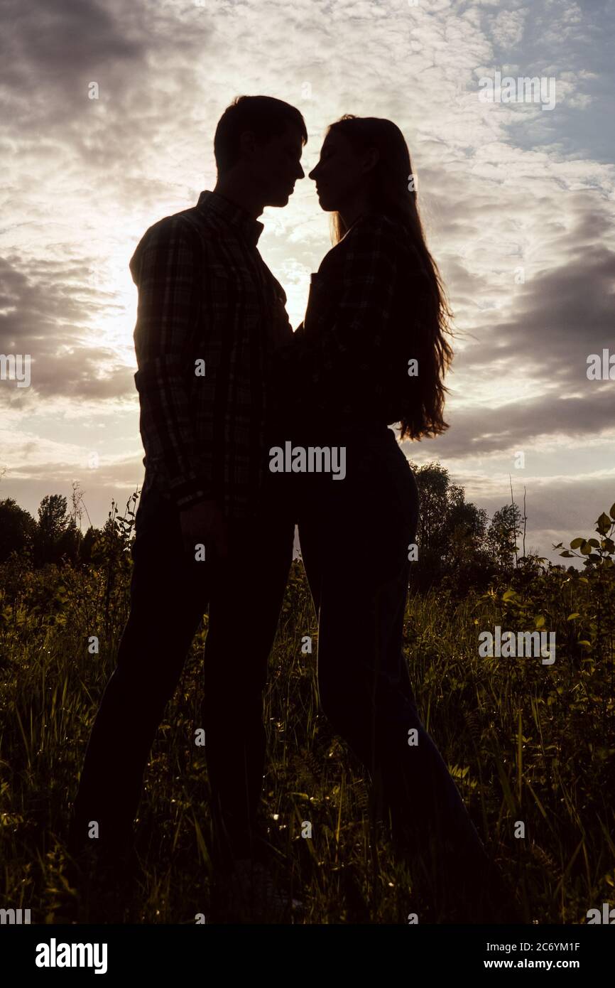 A couple in love in the field on beautiful sky background. Profile ...