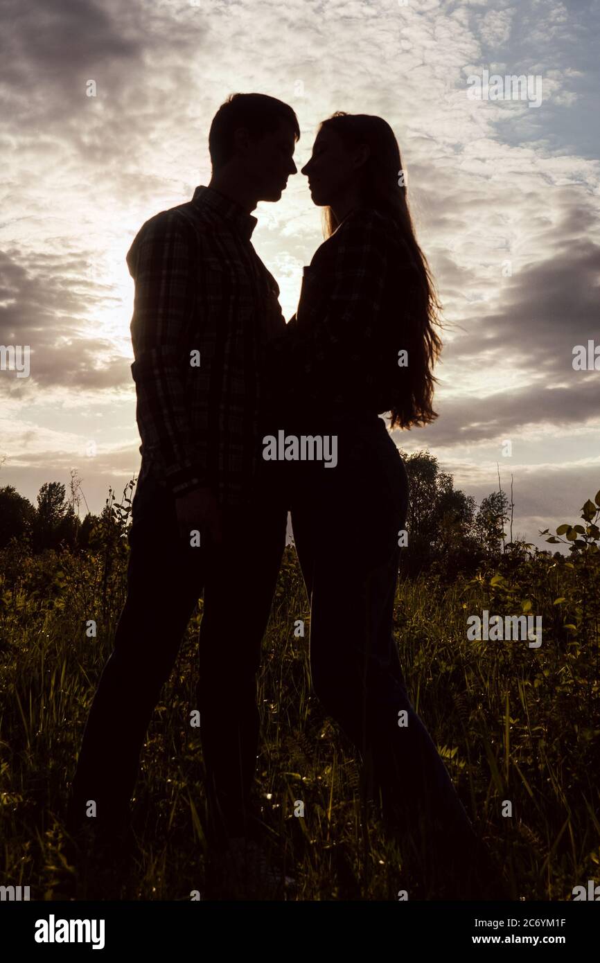 A couple in love in the field on beautiful sky background. Profile