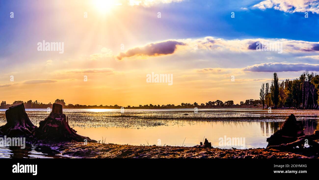 Beautiful panoramic view of the lake, colorful clouds illuminated by the evening sunlight, the luxury of summer adventures, outdoor activities, touris Stock Photo