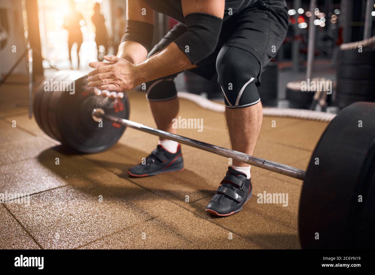 Close up of young active powerlifter dressed in black sporty shorts and
