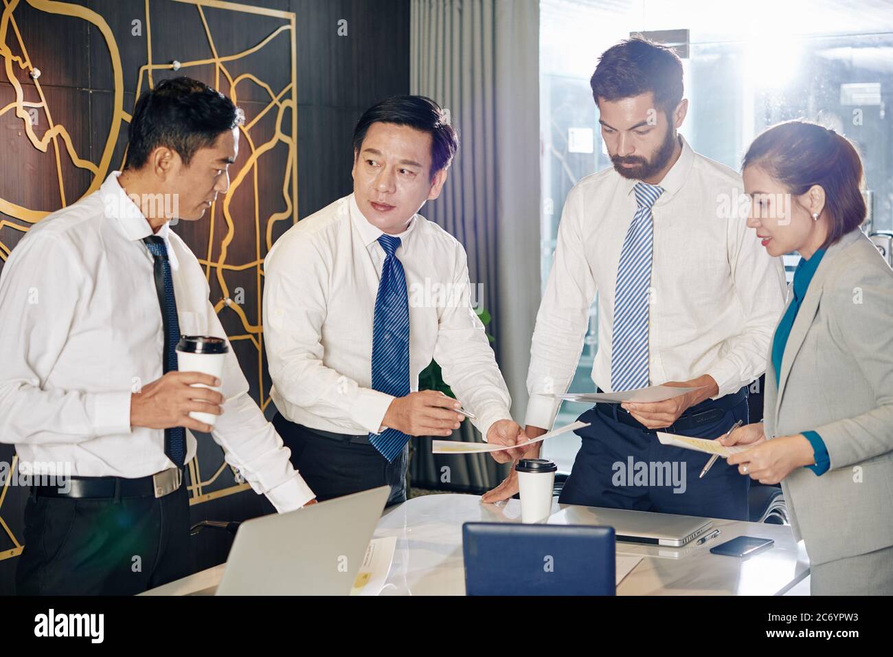 Business team gathered in meeting room to discuss reports and financial documents and trying to find the best way to overcome financial crisis Stock Photo