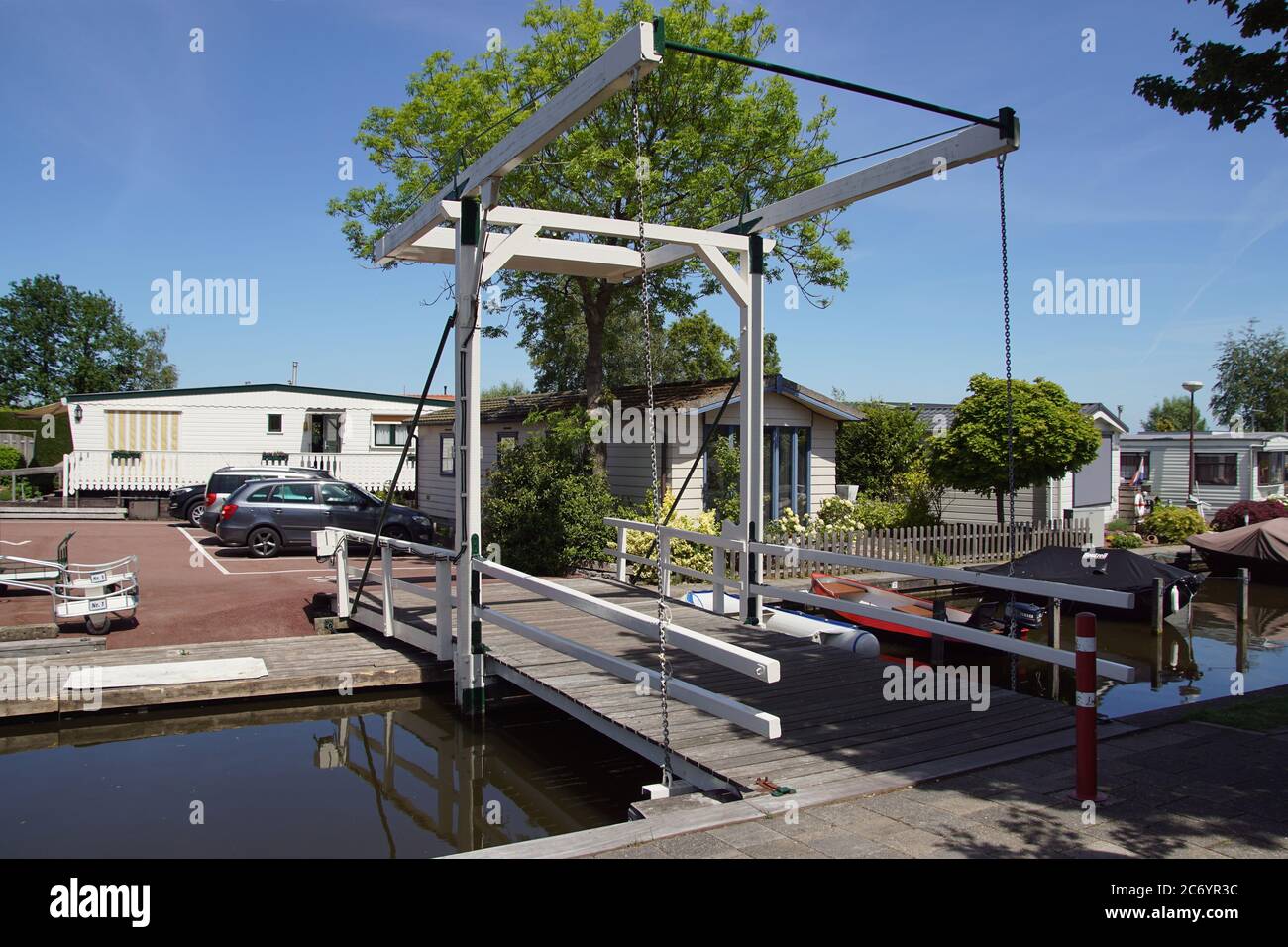 Holiday bungalows, boats and drawbridge in the Dutch village Akersloot at the Alkmaardermeer lake. Netherlands, May Stock Photo