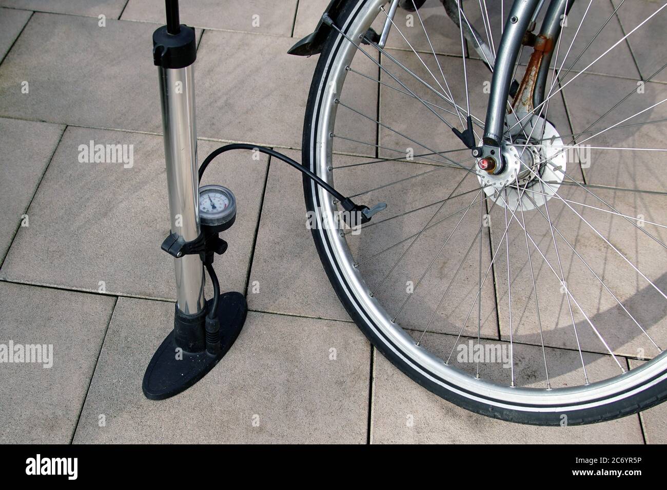 Inflating a bicycle tire with a bicycle pump. Hand air pump with