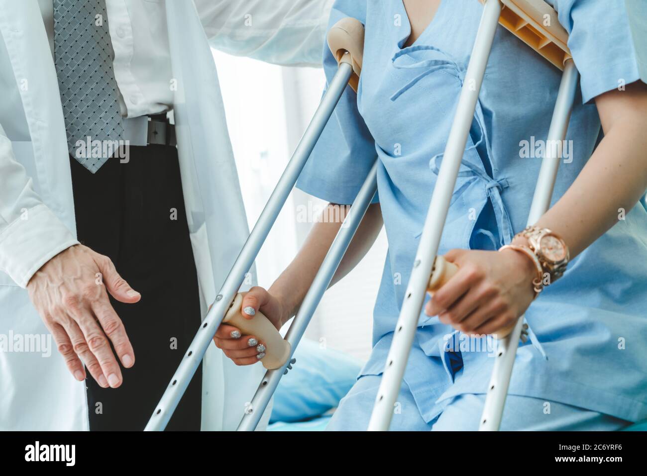 Doctor takes care of patient in crutch at hospital Stock Photo Alamy