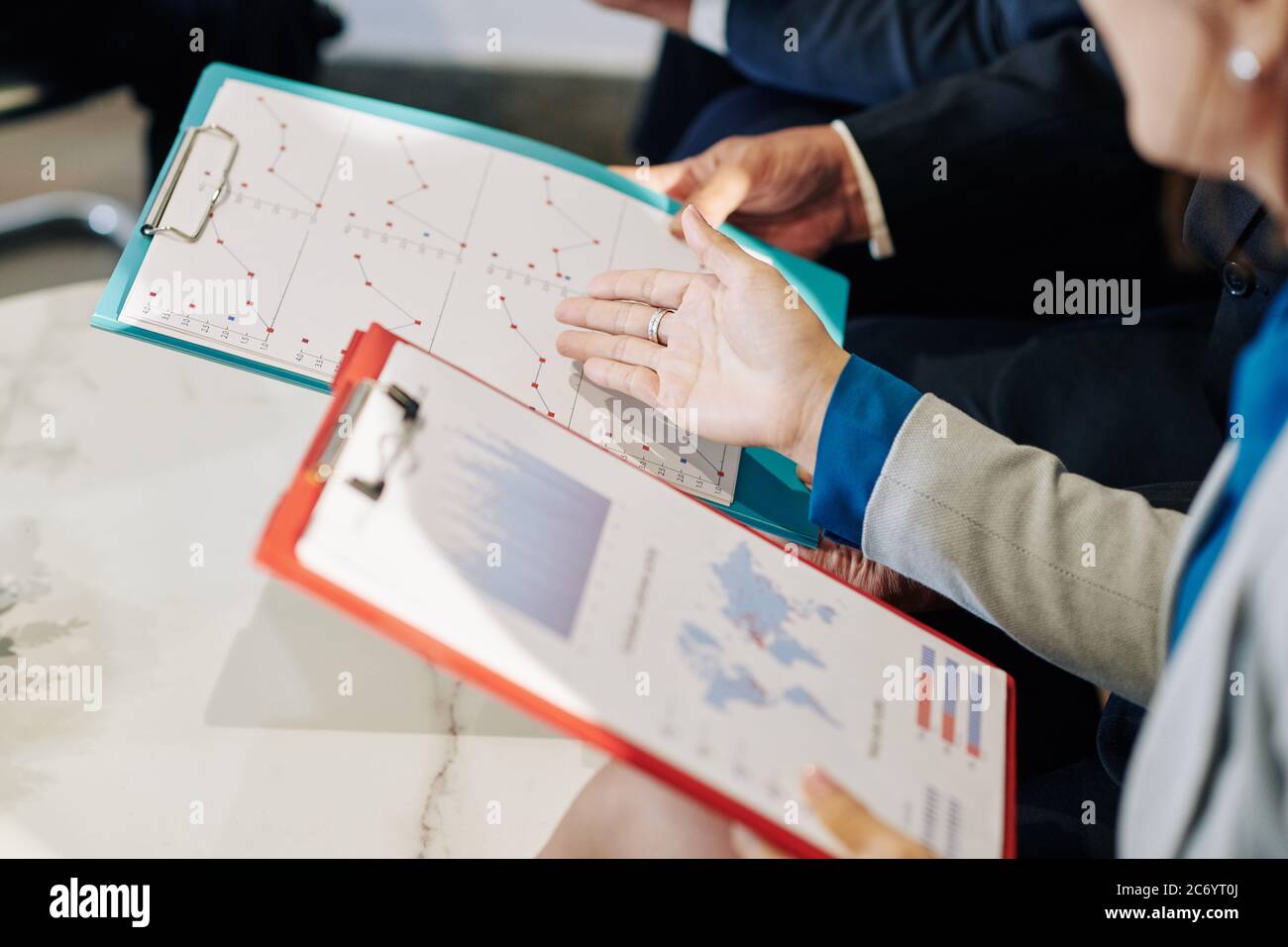 Business executives discussing reports and financial documents at meeting Stock Photo
