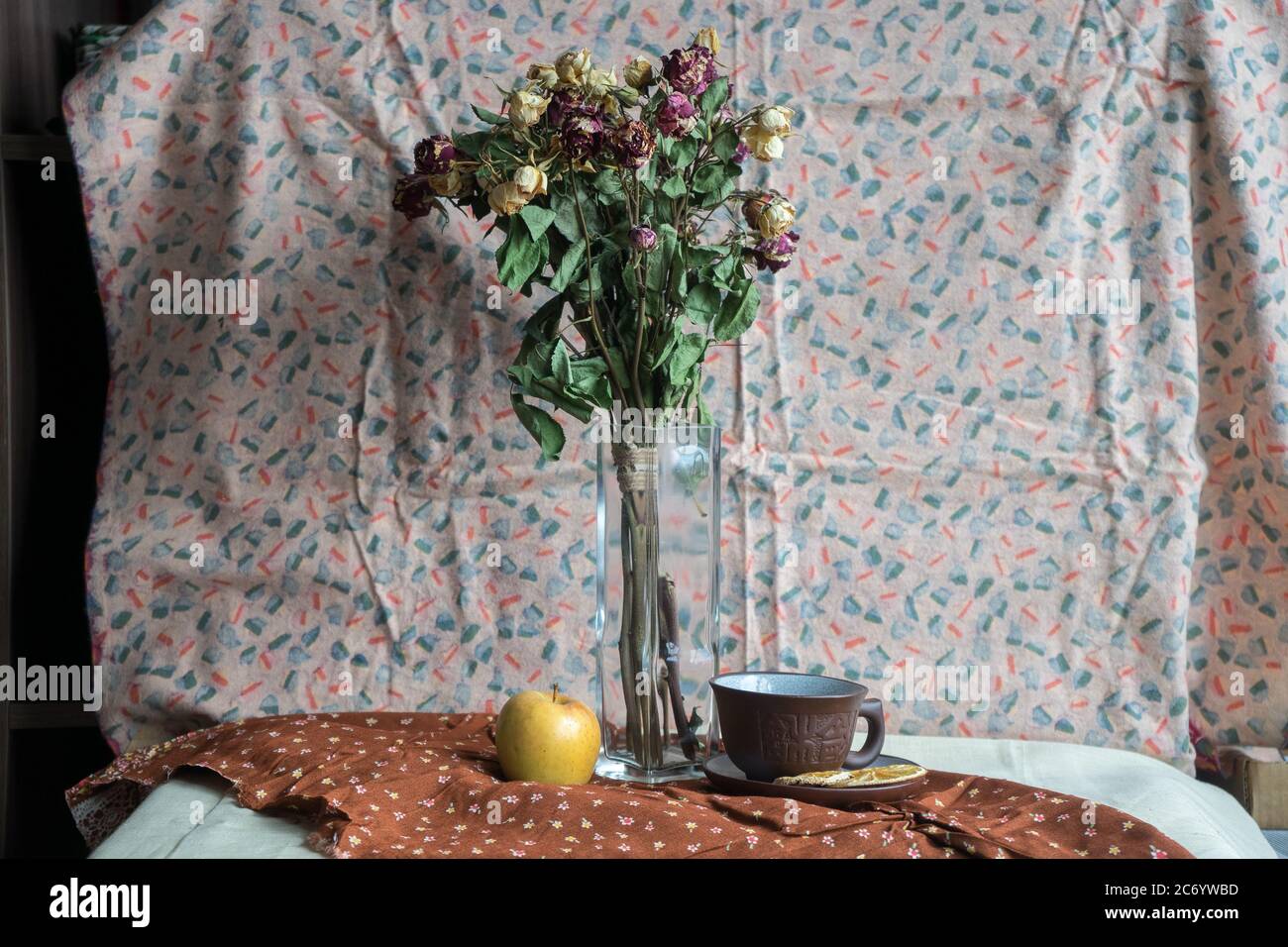 Still life with dried roses, apple and a cup Stock Photo - Alamy