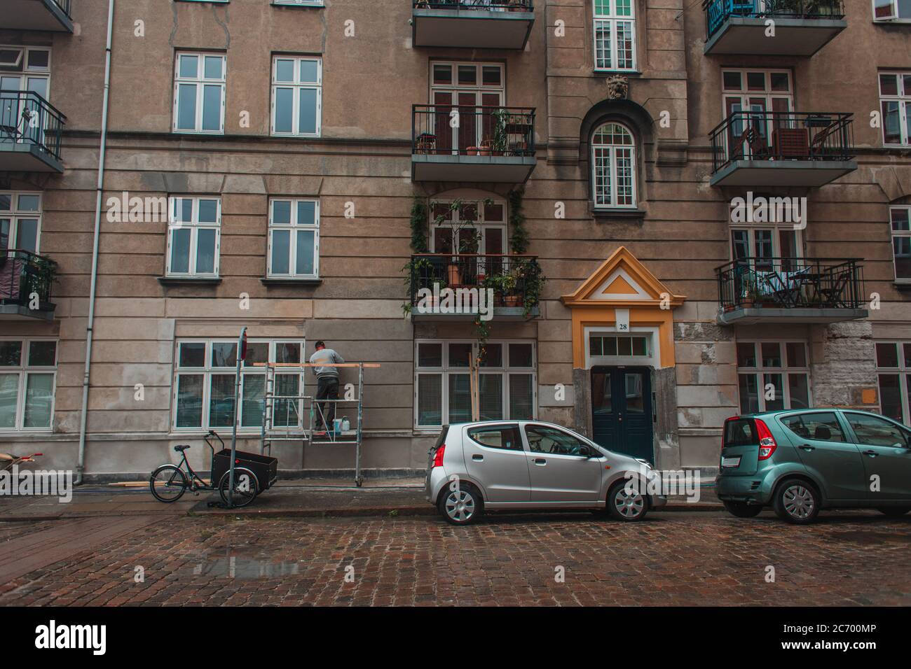 Cars on road near facade of building on urban street in Copenhagen