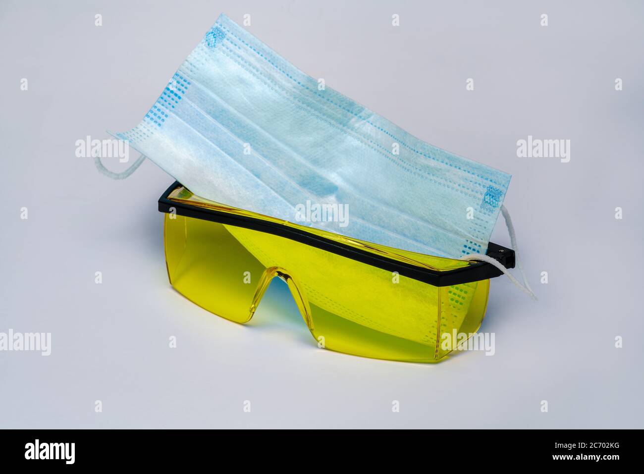 mask and safety glasses for personal protection over light gray