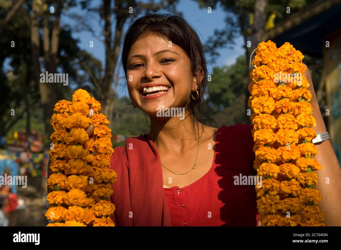 Smiling Nepalese woman selling flowers at monkey temple in  Kathmandu, Nepal Stock Photo
